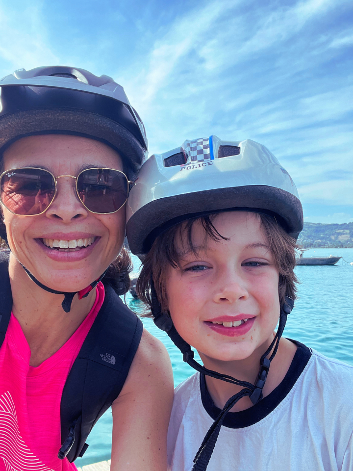 woman and son wearing bicycle helmets on bike ride around lake annecy
