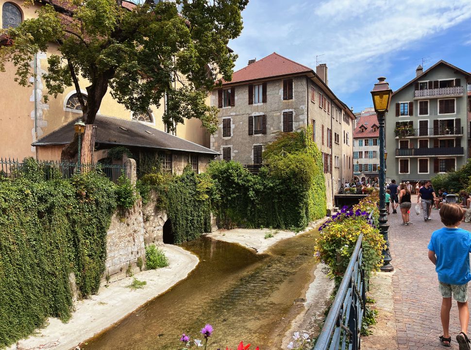 little stream flowing into the city under bridges and tunnels in Annecy town