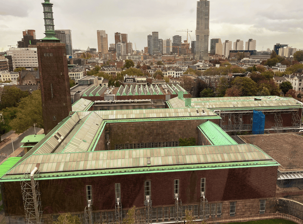 the rooftop of the musuem with Rotterdam city in the back showing a mix of old houses and new skyscrapers