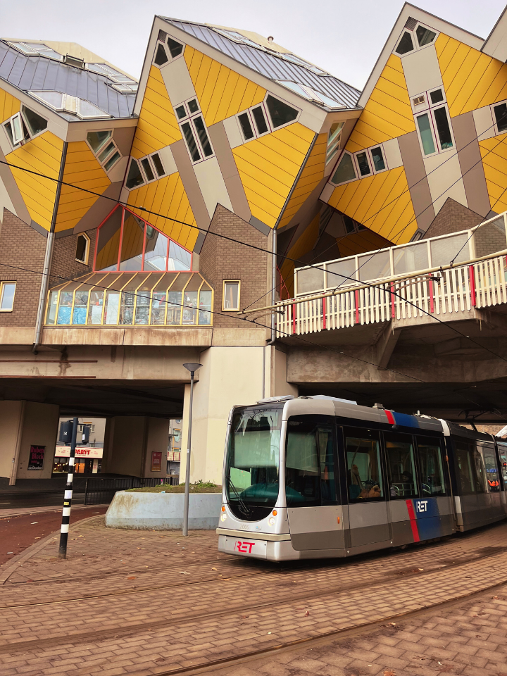 The yellow cube houses in Rotterdam with a tram passing underneath