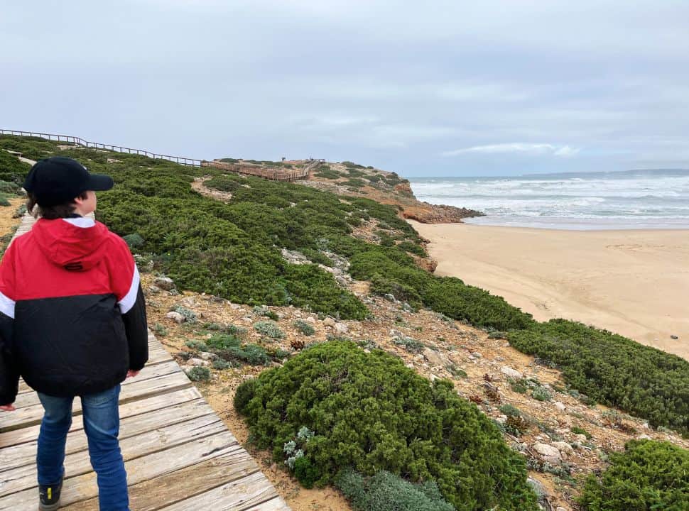 walking along the beach in the algarve with cloudy skies