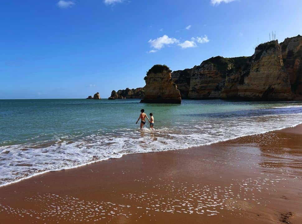 two people going for a swim at Praia Dona Ana