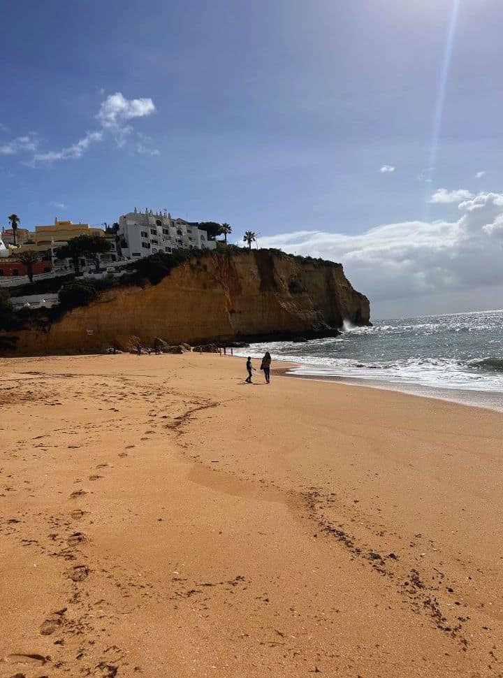 wandering along carvoeiro beach with cliffs on the background