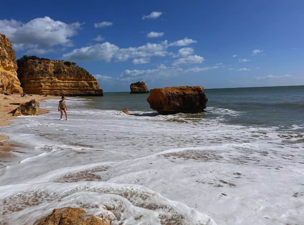 walking through the water at praia da marinha during our 3 day algarve itinerary trip