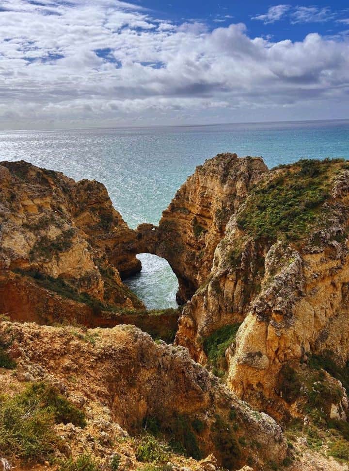 an arch in the cliffs along the coast of the algarve