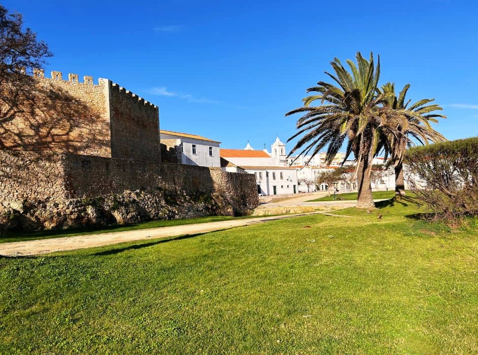 view of lagos city in portugal, the city walls, church and palmtrees