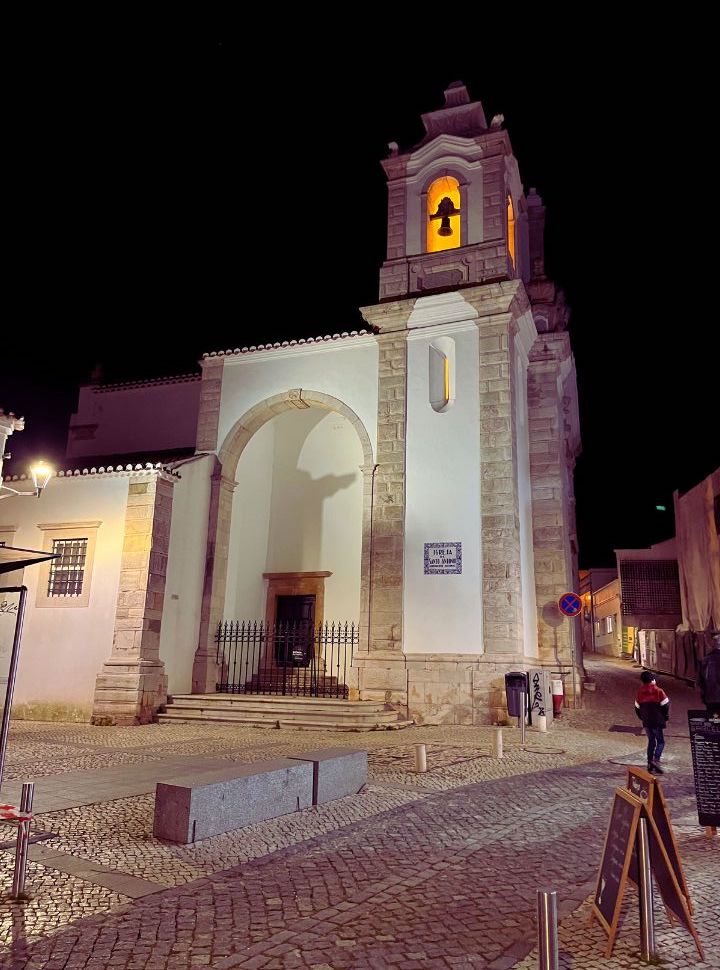 historic church, bell tower is lit at night in lagos portugal