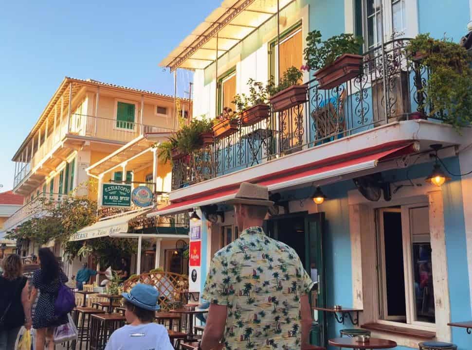 Father and son walking through the main street of Lefkada old town, restaurants with terraces
