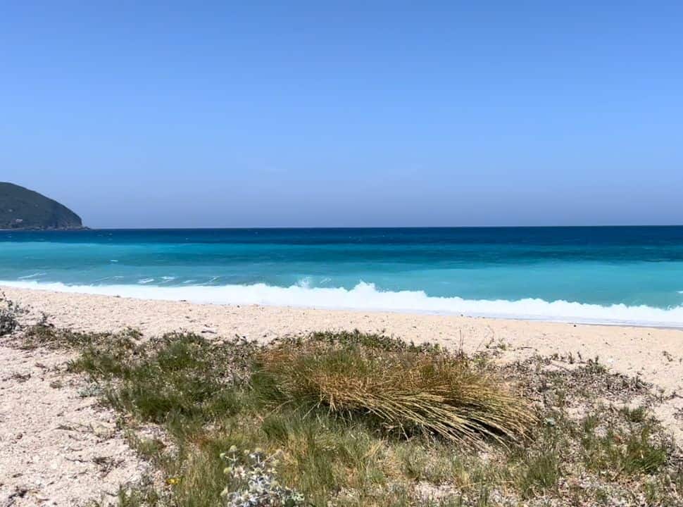 blue water with waves at a long stretched beach located north of lefkada town