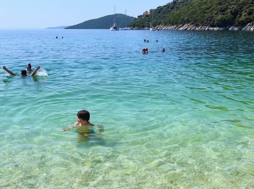 boy enjoying the calm clear water at mikros gialos beach