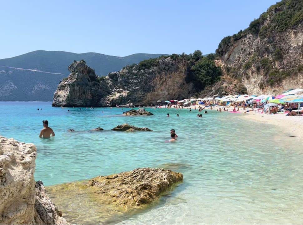 view of the crowded Agiofili beach from the calm clear water