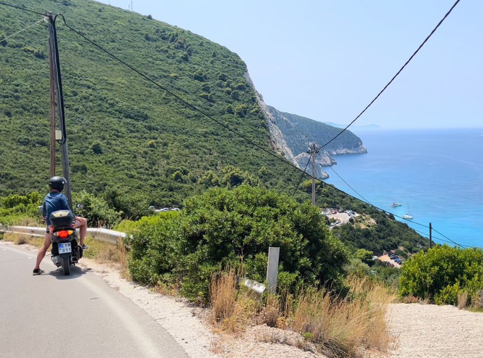 scooter driver enjoying the view of porto katsiki beach lefkada