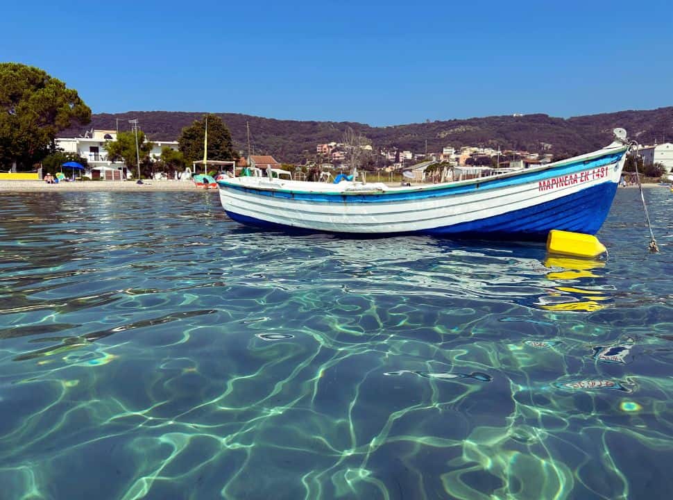 fishing boat in stunning water just off the coast of a beach