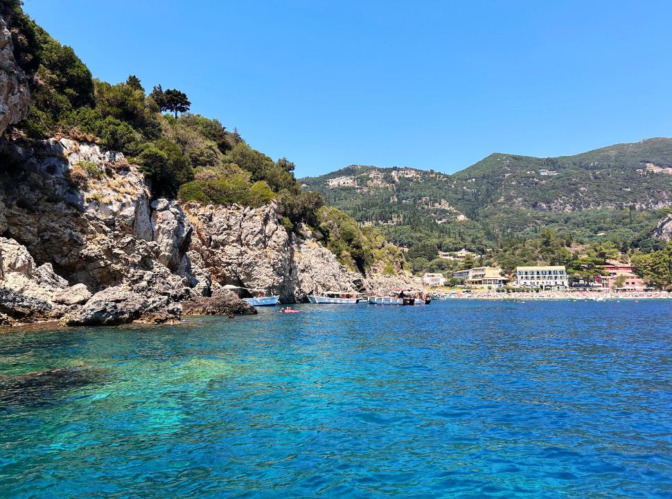 view of paleokastritsa corfu beach from the water with beach accommodation