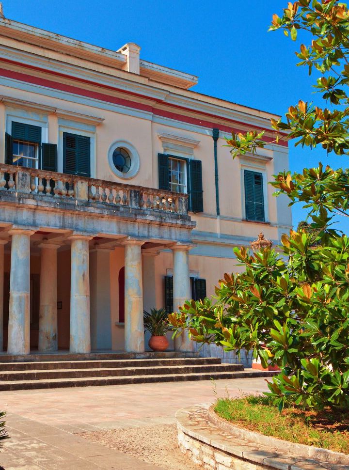 a big mansion with a balcony, columns and garden now houses a museum near corfu town