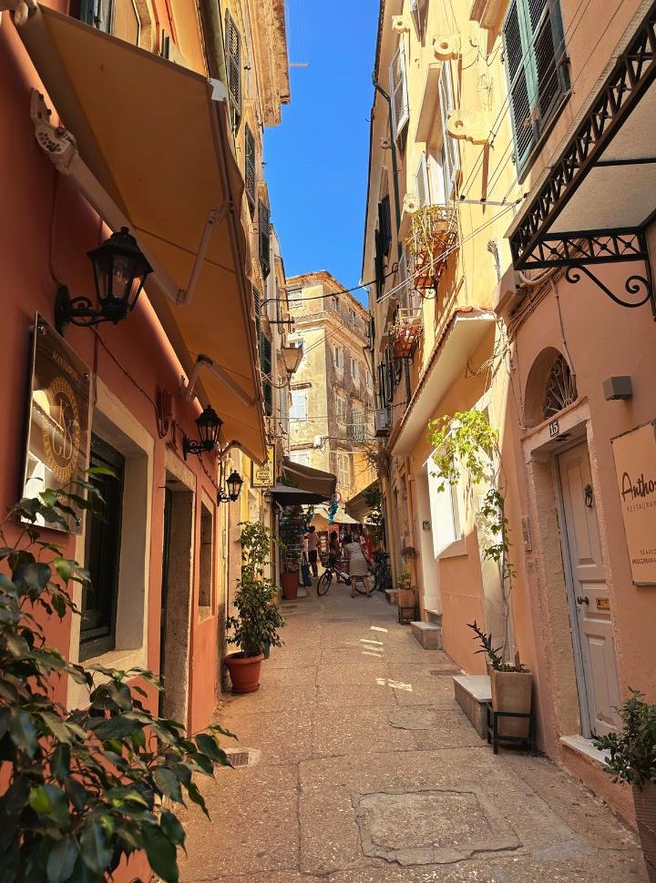 beautiful narrow street in corfu old town with coloured houses and doors