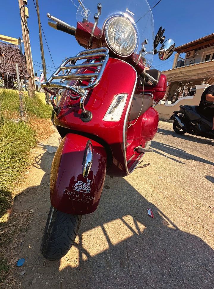 red vespa with the logo of the company that rents it out in corful town