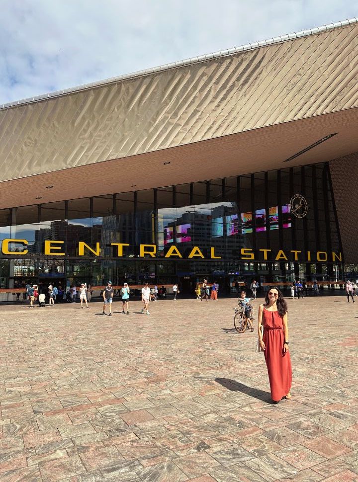 woman posing in front of rotterdam central station