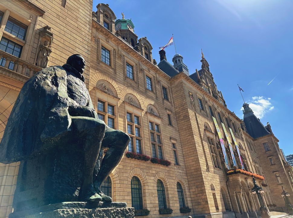 impressive city hall in rotterdam with a close up of a statue