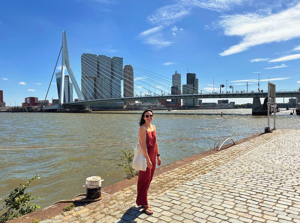 woman posing in front of the Erasmus bridge in Rotterdam