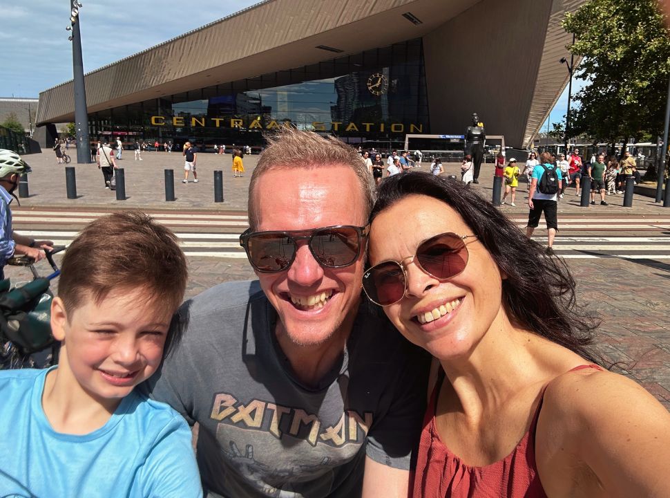 family posing for a picture in front of Rotterdam Central Train Station