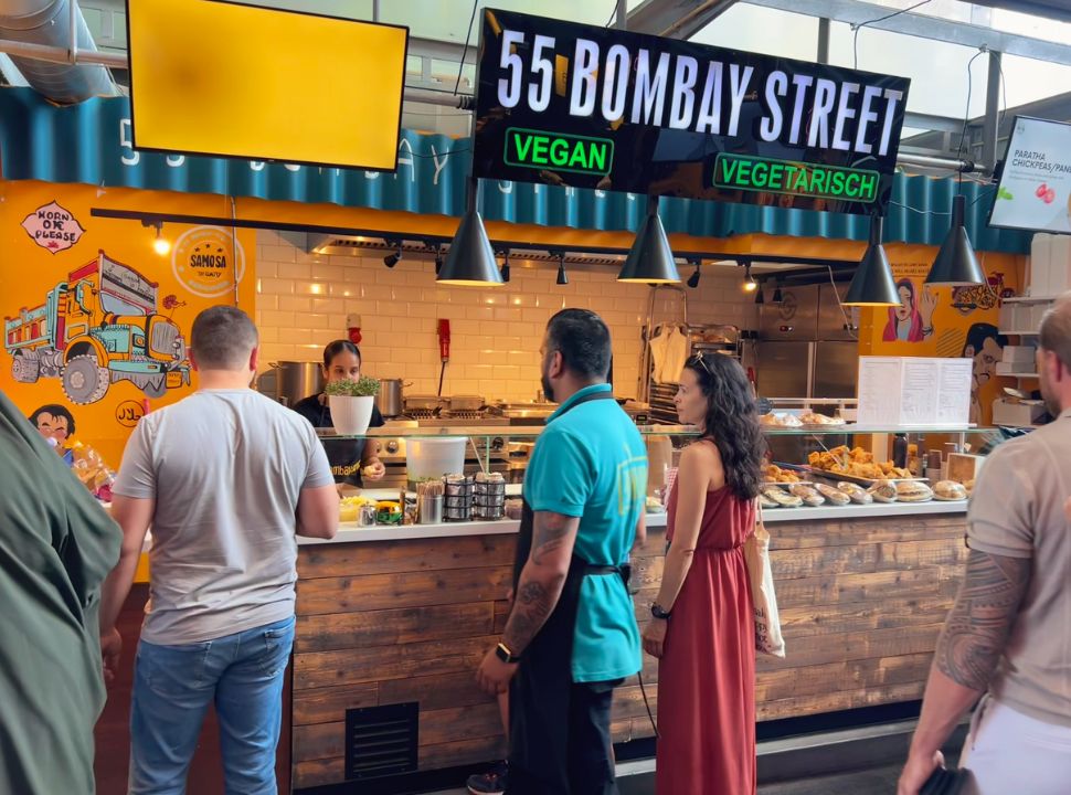 people waiting for their turn at an indian food stall where they serve vegan and vegetarian food