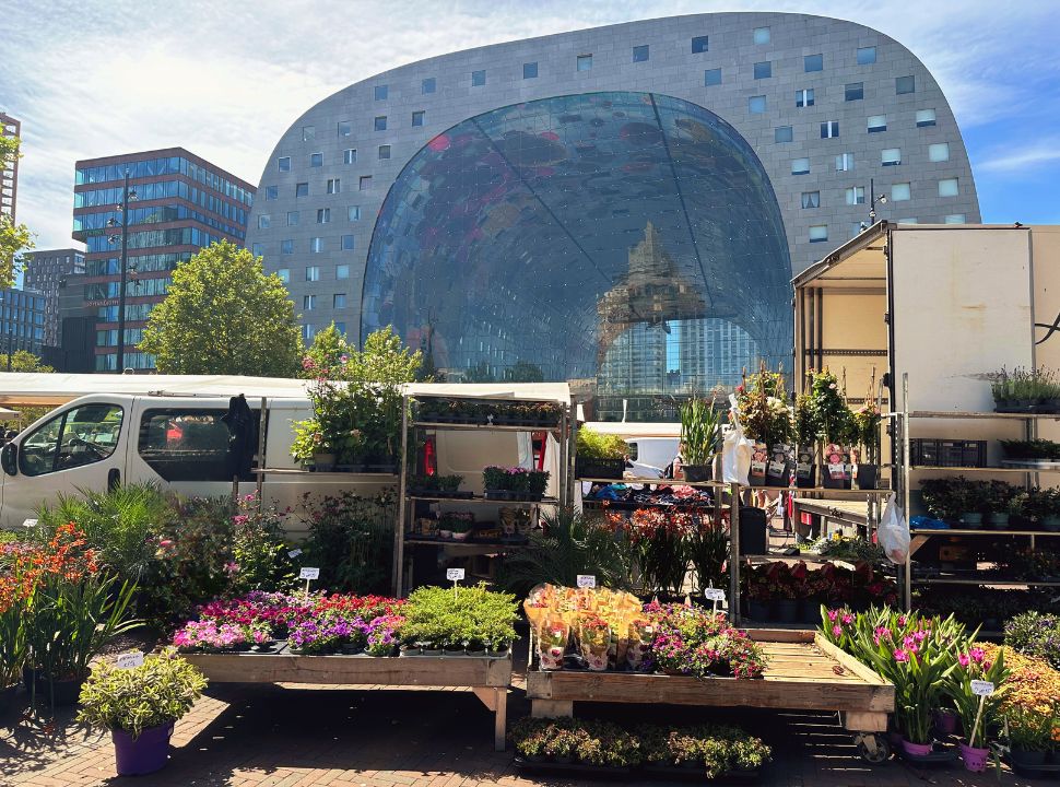 flower stall in front of the iconic building market hall that has the shape of a horse shoe