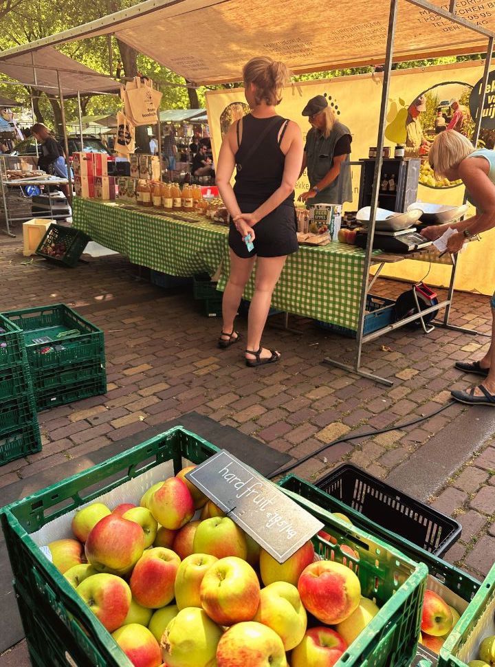 market stand with fresh apples, juices and more at the market in Rotterdam