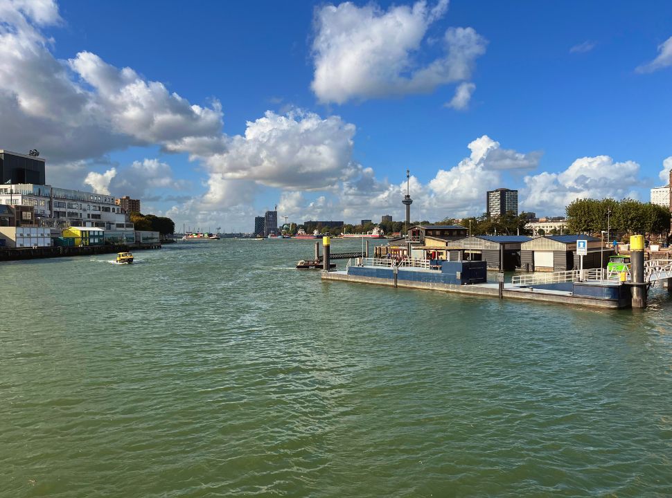 watertaxi approaching the water taxi stand at the river front, in the far distance you can see the Euromast in Rotterdam