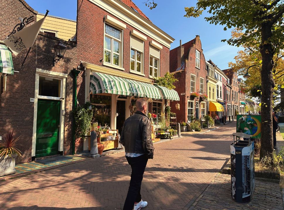 Man walking through a picturesque street with a flower shop in city center Delft