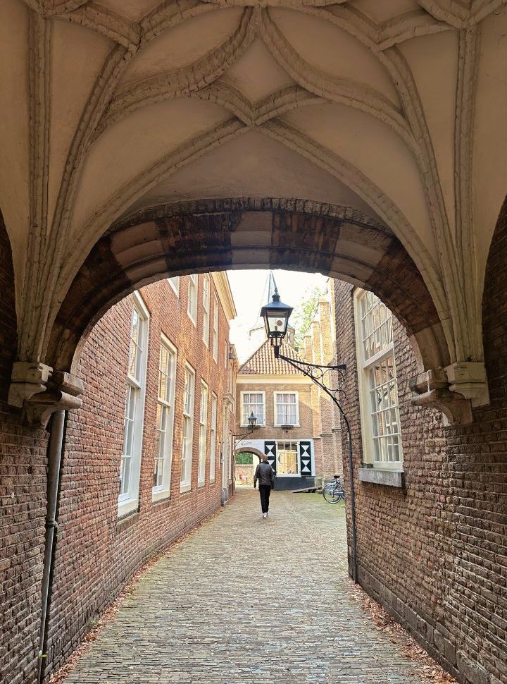 man walking through the gates and courtyard in Delft