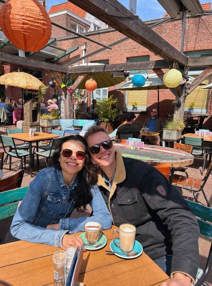 couple posing for a picture at a outdoor terrace of a colorful decorated restaurant, coffee is served