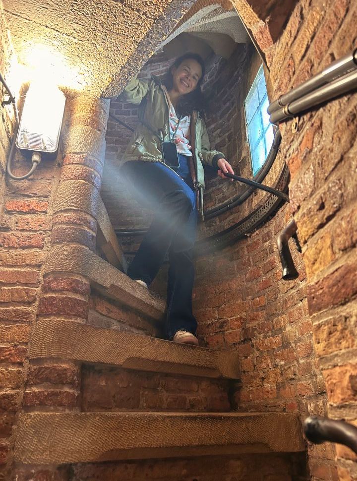 woman climbing down the narrow towers stairs of the new church delft