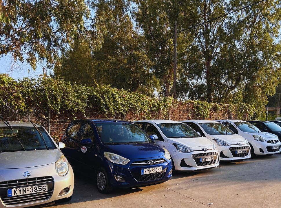 row of cars parked at a rental company in corfu