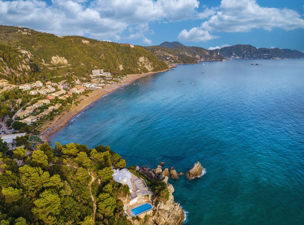 view of a calm ocean and a long stretched beach with a lot of accommodations. 