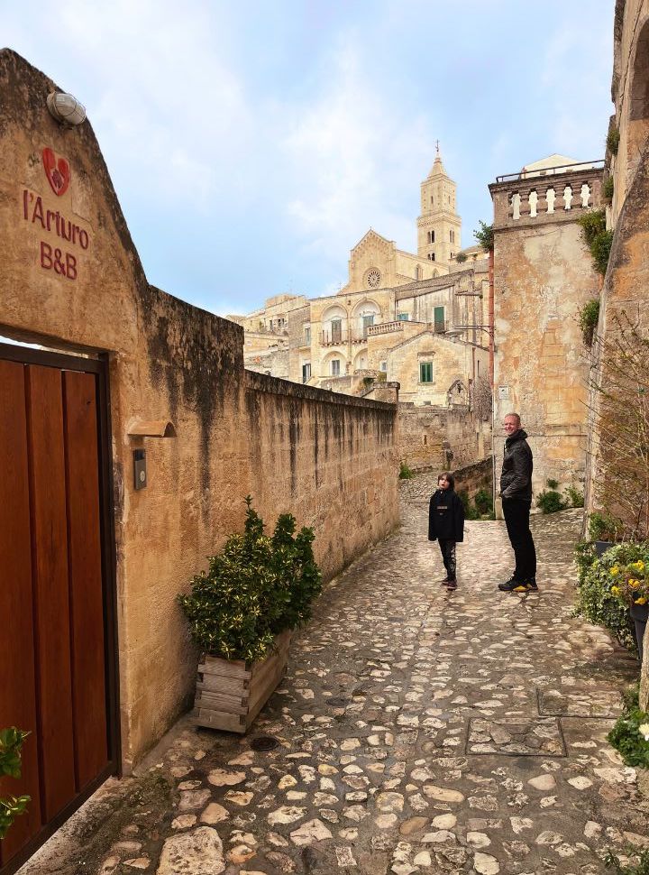 father and son walking through a narrow street in Matera Italy