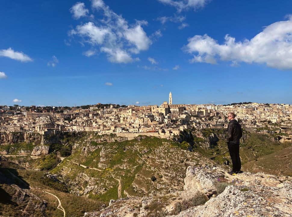 man admiring the view of Matera located on the other side. ofthe valley