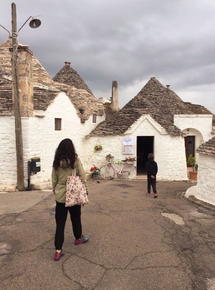 mother and son exploring the streets of Alberobello with trulli houses