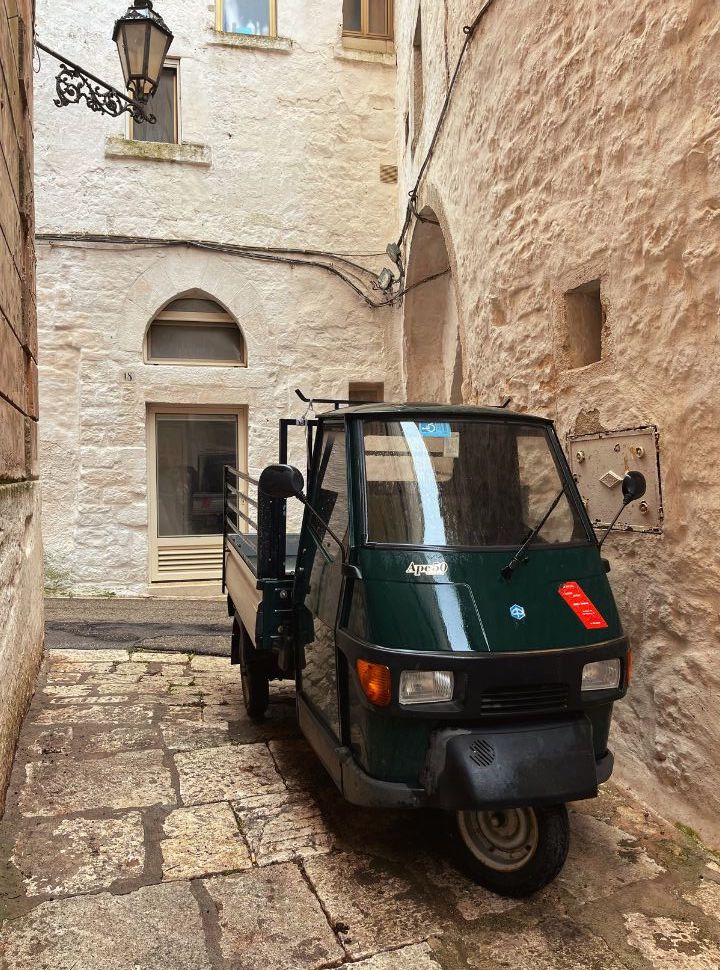 green ape 50 piaggio parked in narrow cobbled streets in Puglia Italy