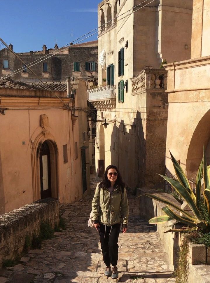 woman climbing up the stairs in a narrow street in Matera