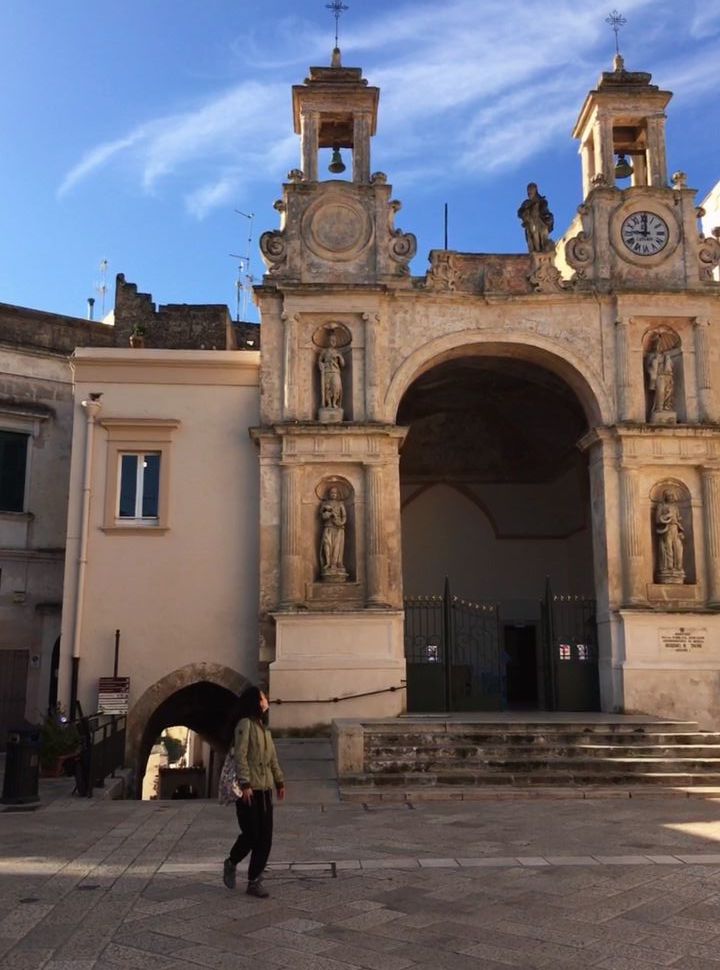 woman exploring a square with a cathedral in Matera puglia