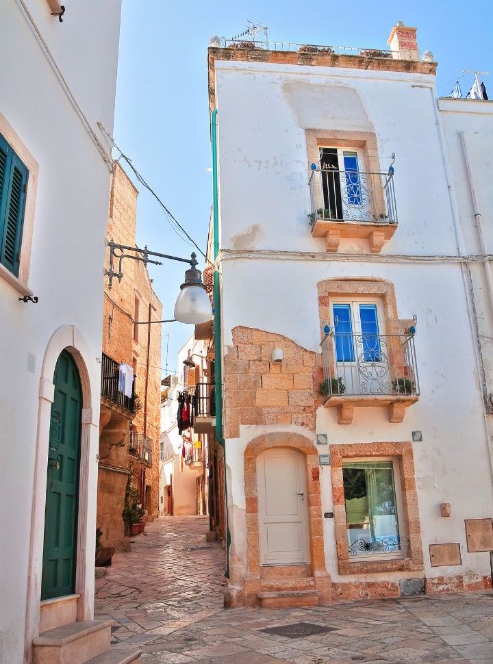 narrow cobbled alley with tall narrow buildings in Polignano a mare