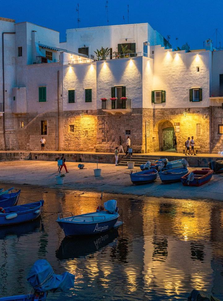 waterfront by night in Monopoli, boats in and out of the water. 