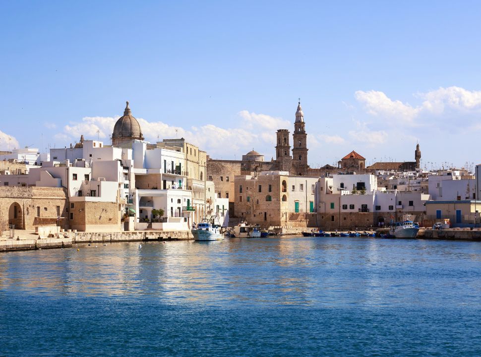 view of the city water front with cathedrals towers rising above the white buildings in Monopoli Italy