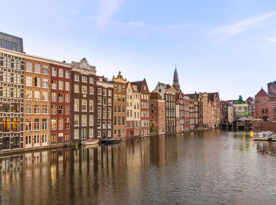 row of typical Amsterdam houses located right at the canal 