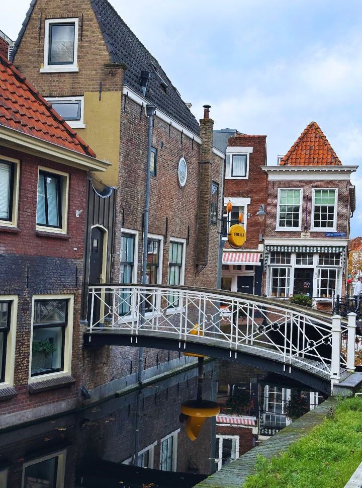 small bridge crossing a canal along old styled dutch buildings in Gouda The Netherlands