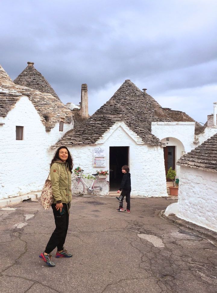 mother and son exploring the streets of Alberobello known for the cone shaped roofed houses. 