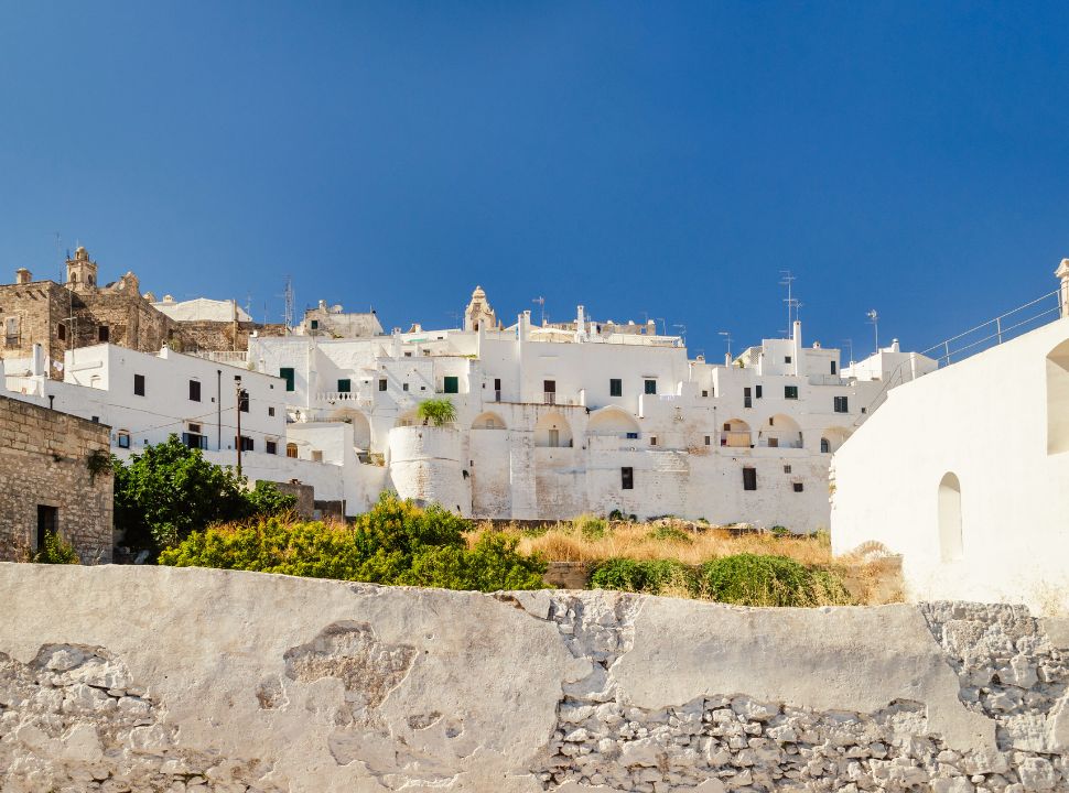 the white buildings of ostuni puglia with a church standing out on the top of the hill