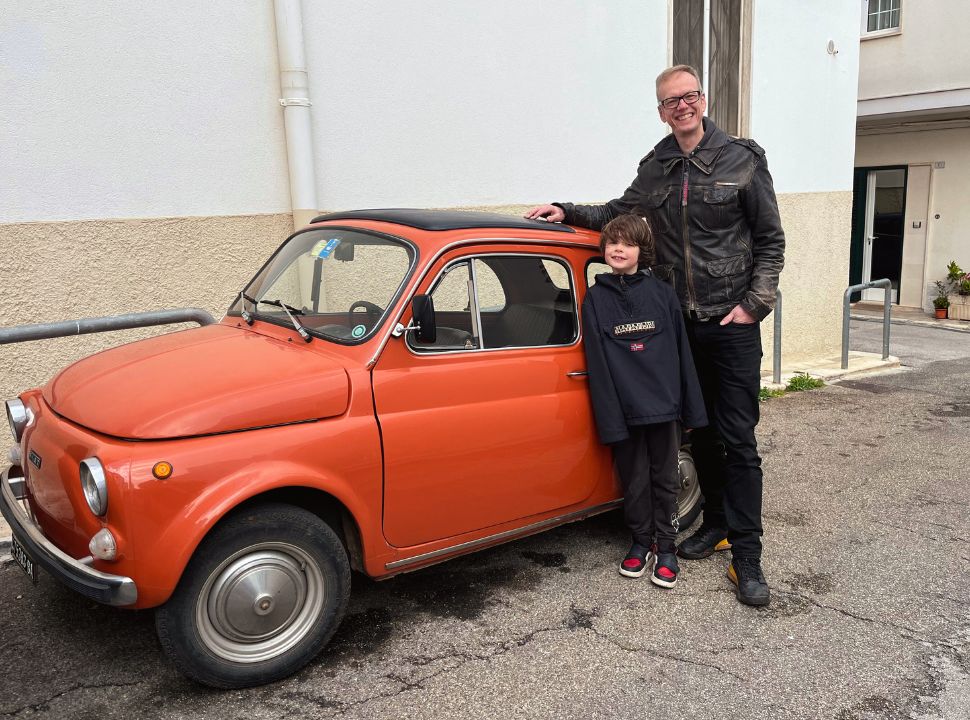 father and son posing at a classic fiat 500 in puglia