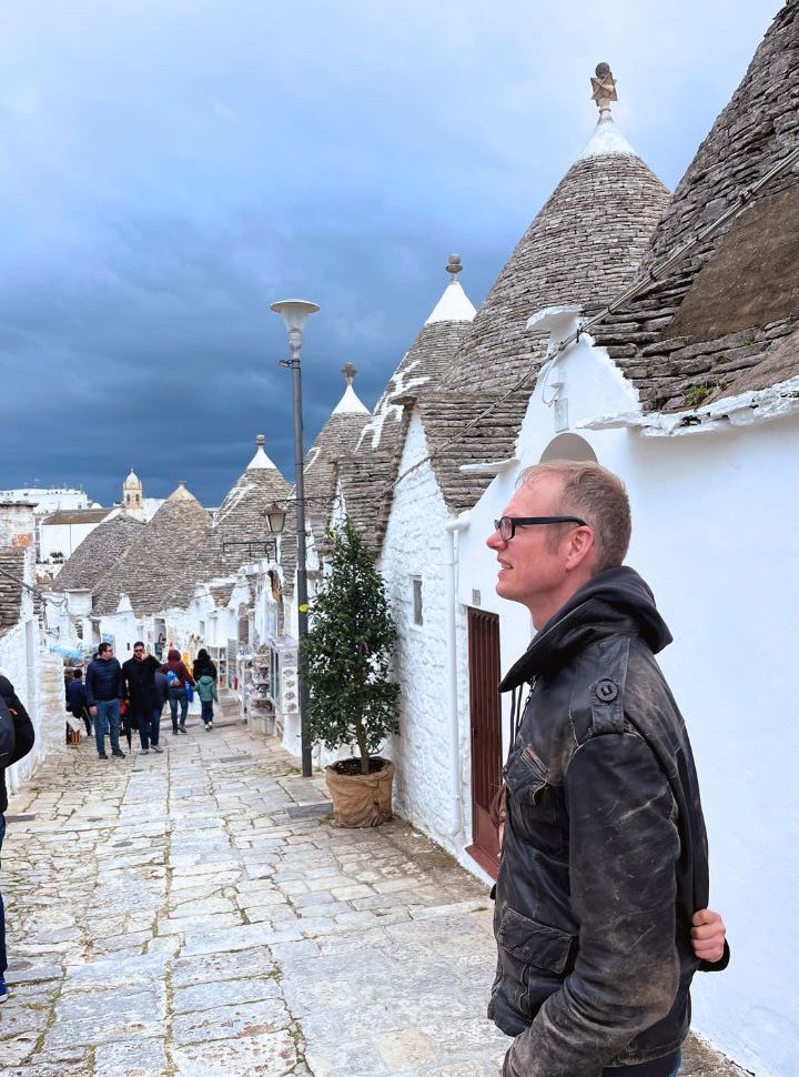 man taking in the unusual but beautiful trulli houses in Alberobello Puglia Italy